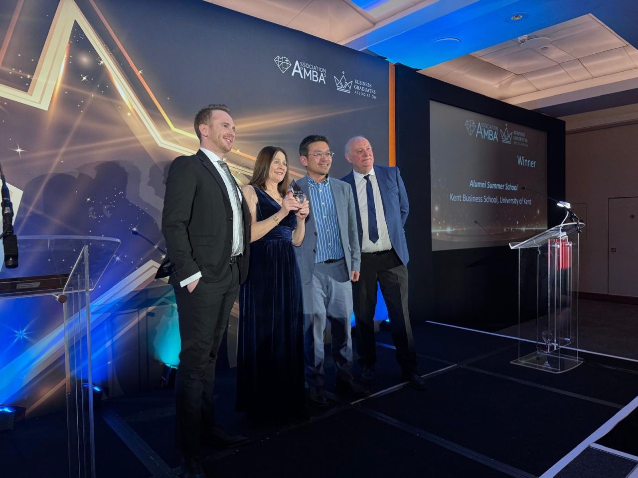 The Kent team pose with their trophy on a stage at the awards ceremony in London