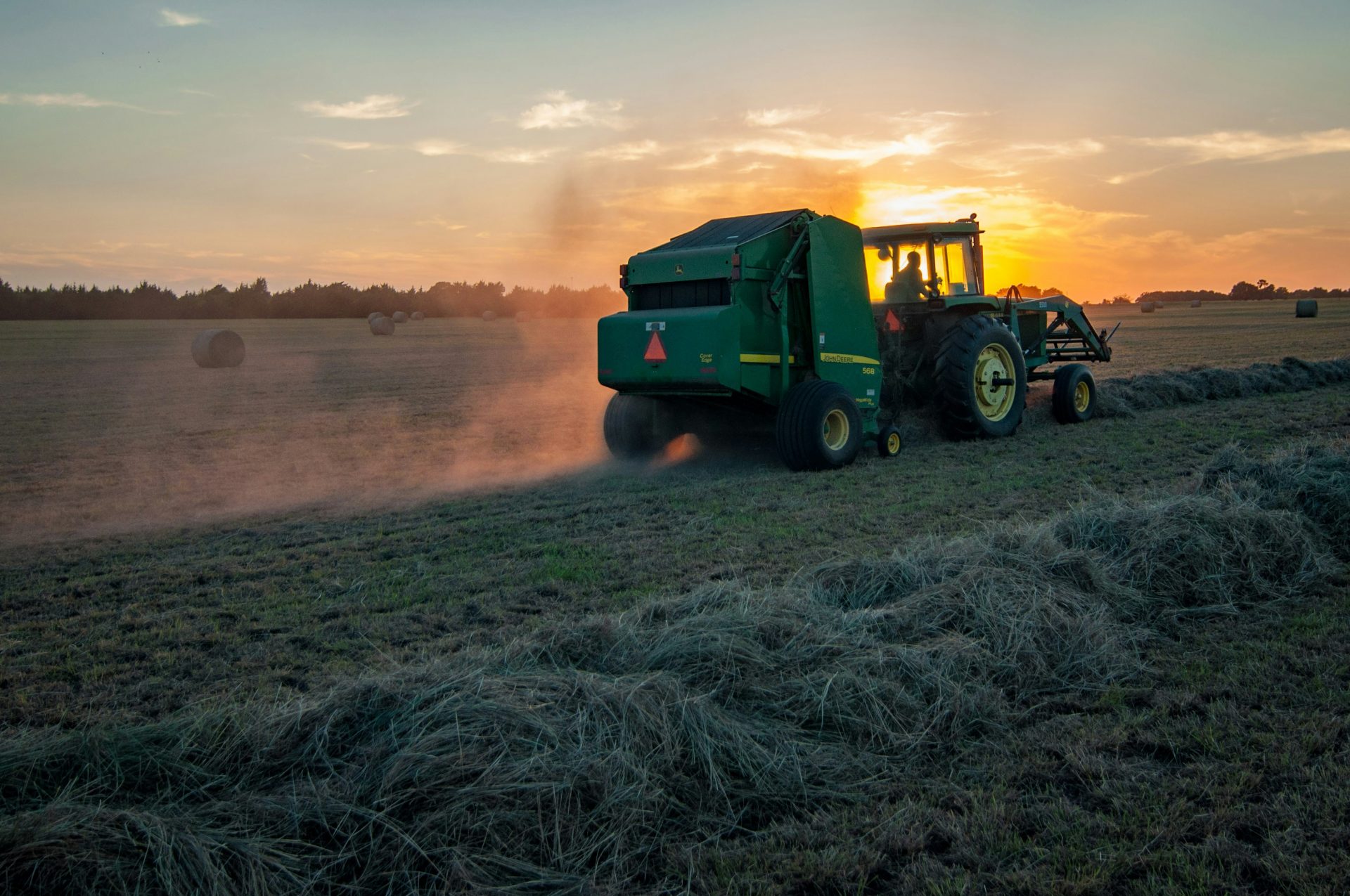 A tractor in a field at sunrise